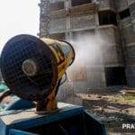 Workers use a Smog Gun to control dust at a construction site in New Delhi. (Express photo by Praveen Khanna)